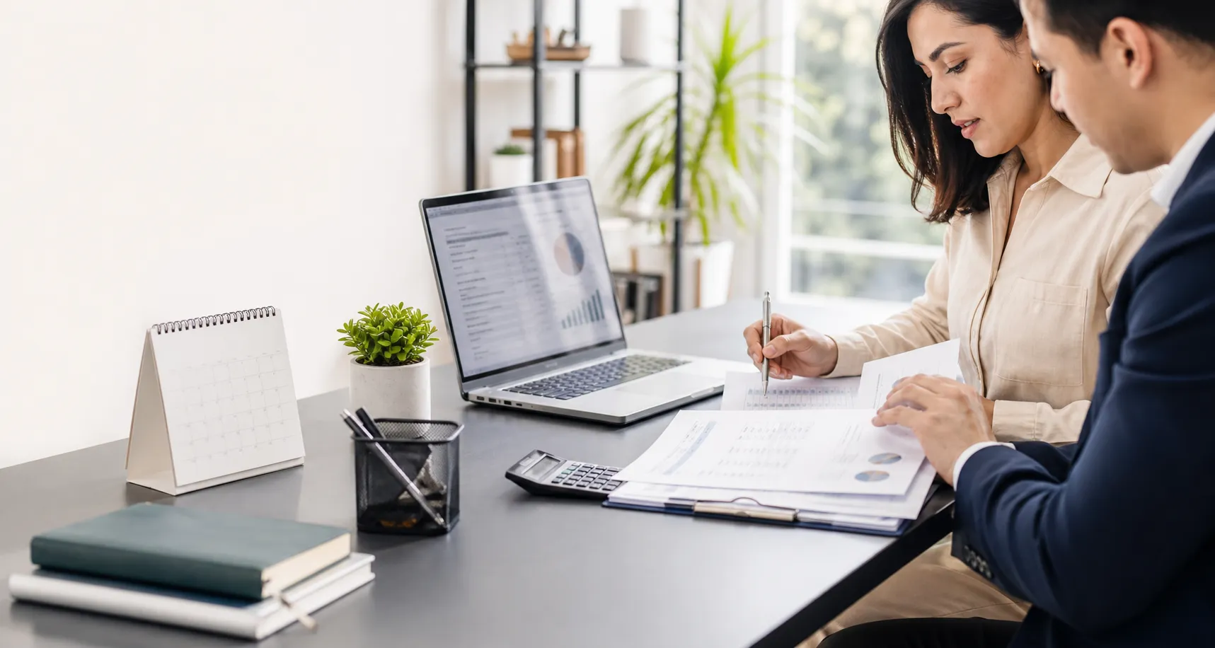 Asesoria administrativa con documentos contables y laptop en una oficina